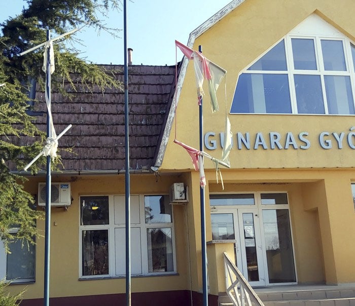 Zászlófoszlányok a gunarasi gyógyfürdő bejáratánál